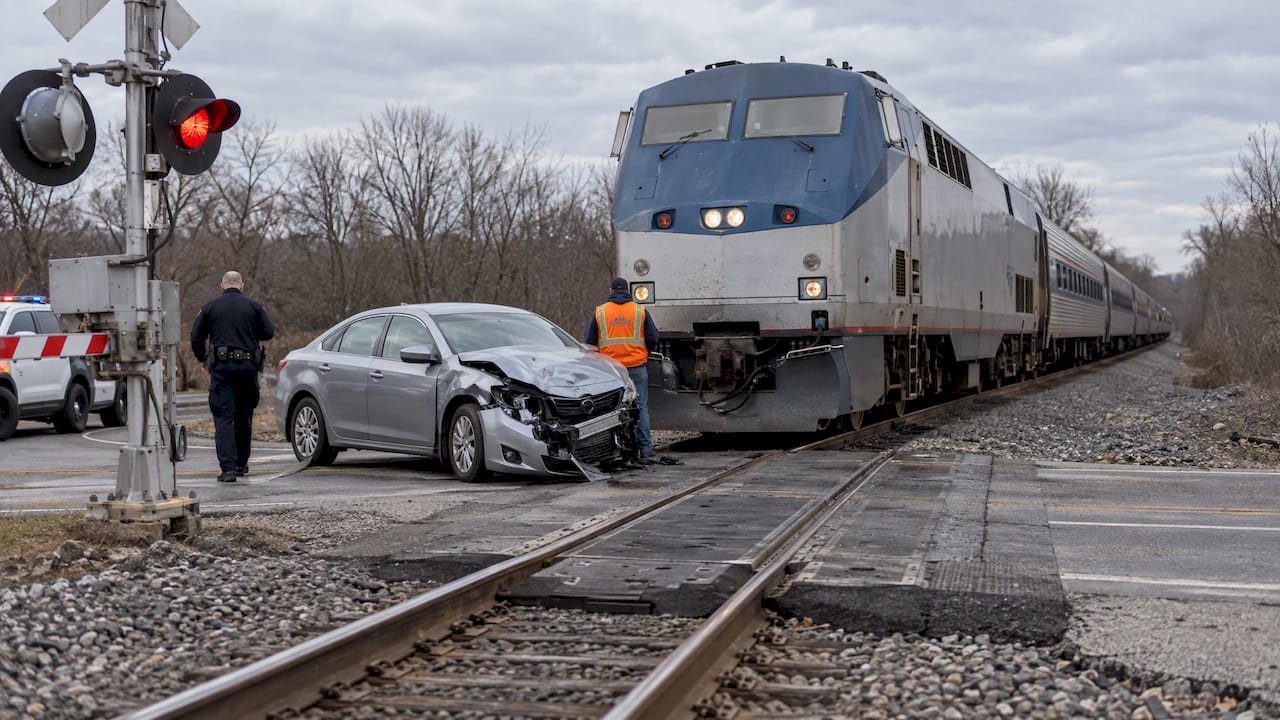 Passenger train stopped beside a damaged car